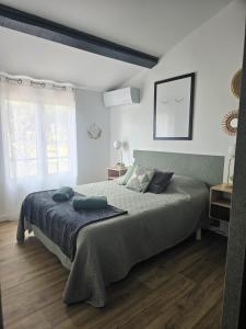 SauvianLe havre de paix - Maison familiale avec piscine et climatisation的一间卧室配有一张大床和两个枕头