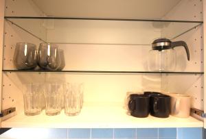 汉诺威Centrally located 2-room apartment的架子上装有杯子和玻璃杯
