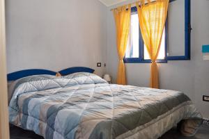 卡拉古诺内Casa Azzurra的一间卧室配有一张带蓝色床头板的床和窗户