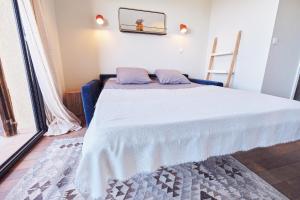 卢米奥Studio standing - Village Lumio的一间卧室配有一张带白色床罩的床