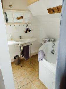 维朗德里埃皮策里高曼德酒店的浴室配有白色浴缸和水槽
