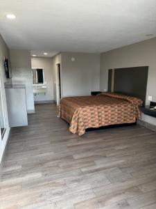 新奥尔良Nola Inn & Suites的酒店客房,设有一张床,铺有木地板