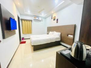 蒂鲁帕蒂Deccan Suites, Tirupati的小房间设有床铺和电视
