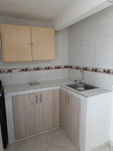 波哥大San antonio urbano的厨房配有白色橱柜和水槽