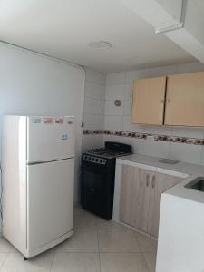 波哥大San antonio urbano的厨房配有炉灶和白色冰箱。