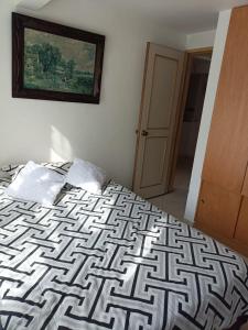 波哥大San antonio urbano的卧室配有一张床,墙上挂有绘画作品