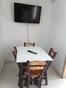 波哥大San antonio urbano的一张带两把椅子的白色桌子和墙上的一台电视