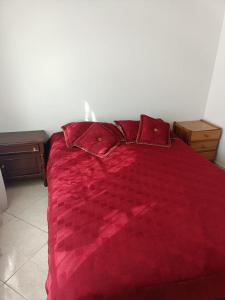波哥大San antonio urbano的卧室内的红色床,配有红色床单和枕头