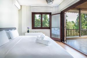莫拉卡里瓦Iconic PRIVE beachfront villa Mola Kaliva的一间卧室配有一张带浴缸和窗户的床。