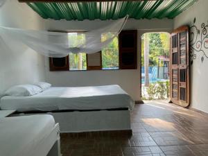 帕洛米诺Hostal Luz de Luna的一间带两张床的卧室,位于带窗户的房间内