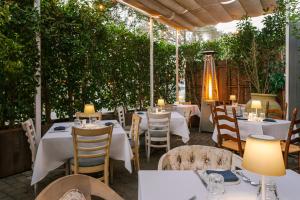 洛杉矶Beverly Terrace powered by Sonder的一间设有白色桌椅的餐厅,种植了植物
