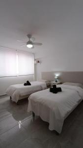 福恩吉罗拉FUENGIROLA CENTRO的客房设有两张床和吊扇。