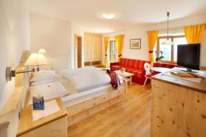 拉伊翁Garni Sonneck的一间卧室配有一张大床和一张红色的沙发