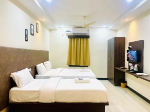 蒂鲁帕蒂Deccan Suites, Tirupati的酒店客房设有两张床和电视。