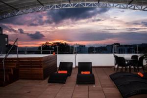 亚美尼亚伊莎维克托里精品酒店的屋顶露台配有椅子和桌子,享有日落美景