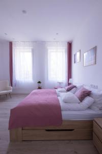 布达佩斯Wagner Villa 902的一间卧室配有一张带粉色毯子的大床