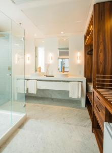 累西腓Hotel Luzeiros Recife的一间带大浴缸和玻璃淋浴的浴室