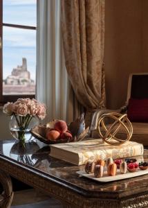 罗马Anantara Palazzo Naiadi Rome Hotel - A Leading Hotel of the World的一张桌子,上面有一本书和一盘水果