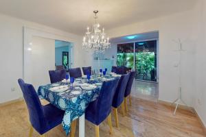 坎昆Villas Tropical 11的用餐室配有带蓝色椅子的桌子和吊灯