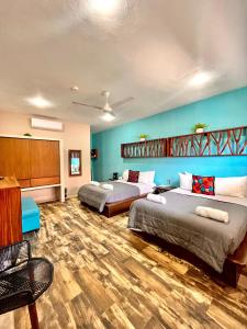 女人岛Bahia Tolok的配有蓝色墙壁和木地板的客房中的两张床