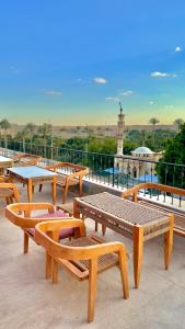 开罗Almas Pyramids Hotel的屋顶上的一组木凳和桌子