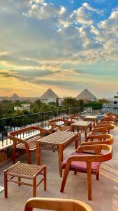 开罗Almas Pyramids Hotel的坐在屋顶上的一排木凳