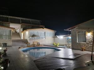 卡诺阿斯德蓬萨尔Akas Hotel Apartamentos的夜间在房子前面的游泳池