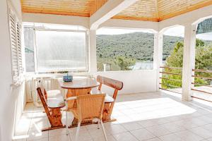 普特尼科维奇Apartments by the sea Luka Dubrava, Peljesac - 14187的门廊上设有桌椅,