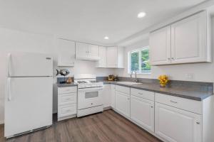 洛杉矶Modern 1-Bedroom Home in a Prime LA Location的厨房配有白色橱柜和白色冰箱。