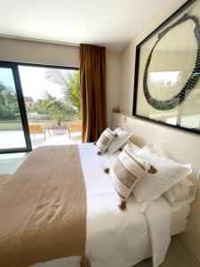 恩加帕鲁Villa YEMAYA - Villa d'hôtes的一间卧室设有一张大床和大窗户