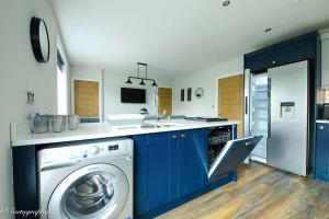 斯卡伯勒Bay View Holiday Apartments的厨房配有蓝色橱柜和洗衣机。