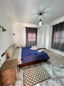 阿伊特本哈杜科萨万年青本哈杜宾馆的一间卧室配有一张带蓝色毯子的大床