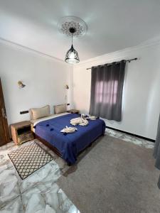 阿伊特本哈杜科萨万年青本哈杜宾馆的一间卧室设有蓝色的床和窗户。