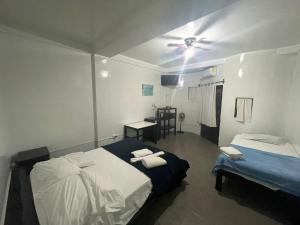 曼克拉Loki del Mar的一间卧室配有两张床和吊扇