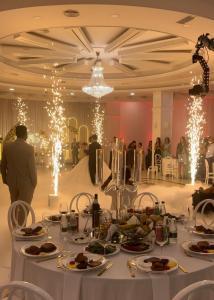 地拉那Misk Hotel & Resort的宴会厅,配有餐桌和盘子