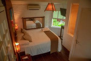 坎布里Alua Camburi的一间卧室配有一张带大镜子的床