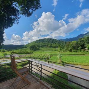 和平Quế Homestay的木凳,坐在甲板上,俯瞰着田野
