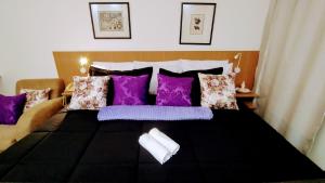 圣保罗Hotel M-RCURE Av Paulista GRAND PLAZA - Master Deluxe king Studio Veranda - Executive Class - By LuXXoR的一间卧室配有一张带紫色枕头的床