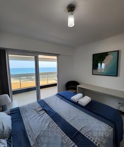 萨尔瓦多Vista Mar Apartamento em Armação的一间卧室配有一张床,享有海滩美景