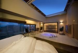 丰田市Spa岛酒店（仅限成人）的卧室内设有一间带浴缸的大浴室