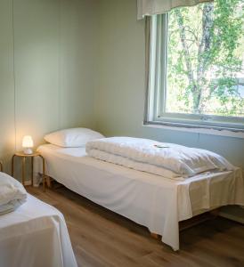 StorforsheiKrokstrand Fjellpark AS的带窗户的客房内的两张床