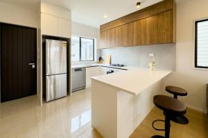 TakaniniBrand New 3Bedroom Retreat in South Auckland的厨房配有白色柜台和黑色冰箱。
