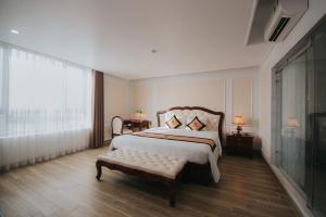 海阳Asean Hotel的一间卧室配有一张床、一张长凳和一个窗户。