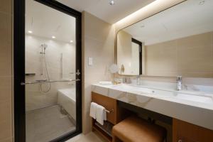 鸟羽图巴国际酒店的一间带水槽、浴缸和镜子的浴室