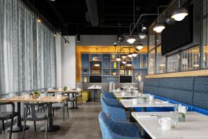 奥兰多Aloft Orlando Lake Nona的一间配备有桌子和蓝色椅子的用餐室
