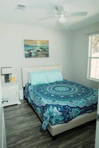 比洛克西Happy Beach House in Biloxi的一间卧室配有一张带蓝色被子的床