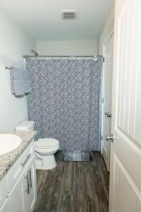 比洛克西Happy Beach House in Biloxi的一间带卫生间和淋浴帘的浴室