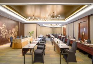 三宝垄Hotel Ciputra Semarang managed by Swiss-Belhotel International的用餐室配有长桌子和椅子