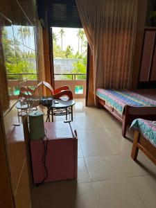 美奈San Vuon Guesthouse的卧室配有一张床和一张桌子及椅子