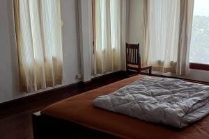 万象MEKONG VIEW VILLE的卧室配有床、椅子和窗户。